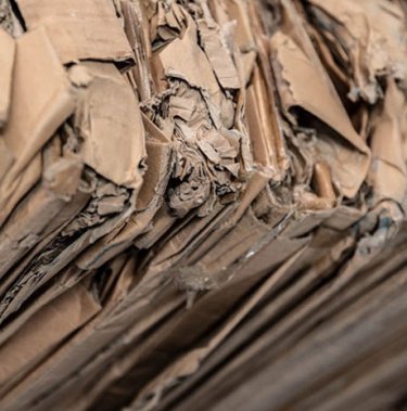 What kind of cardboard should be loaded into the baler?
